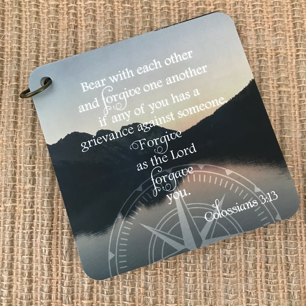Scripture card with Colossians 3:13 printed over a photo of mountains overlooking a very still body of water. Daily scripture card.