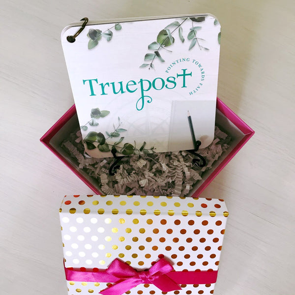 Gift box with the iron display easel and scripture devotional card set taken form the top looking down in the box. You'll see the shredded paper that comes inside the gift box.