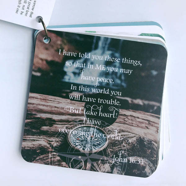 Scripture card of John 16:33 is printed over a photograph of an old compass with the cover opened. It almost looks like an old pocket watch.