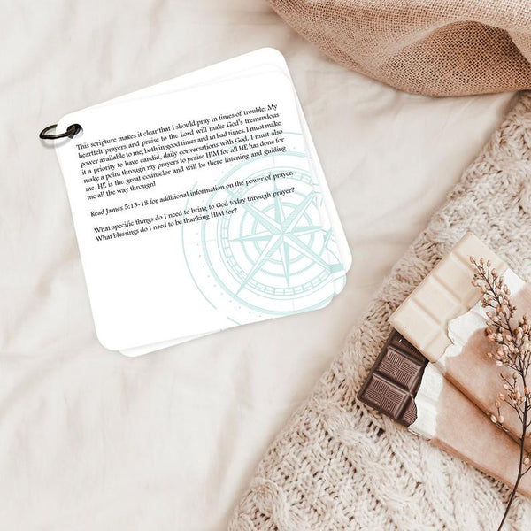 Devotion card on praying in times of trouble laying on a blanket.