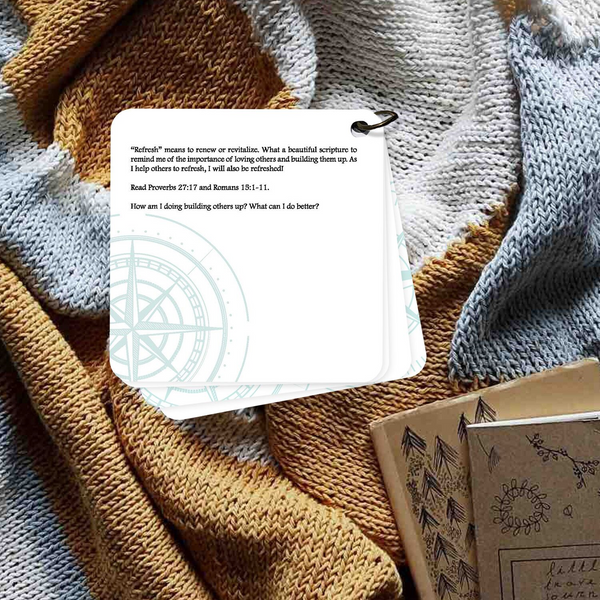 Devotion printed on a card laying on a brown and blue blanket with 2 books laying below.
