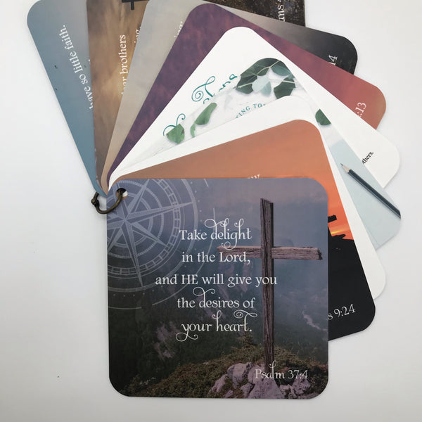 Scripture card of Pslam 37:4 printed over a photo of a cross on a hill. Cards are fanned out on the page. Bible verse gift idea.