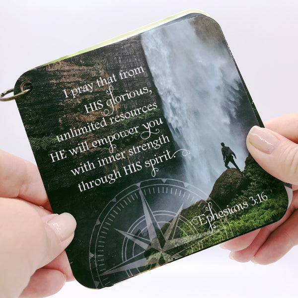 Ephesians 3:16 printed over a photo of a man at the base of a waterfall. Daily Bible verse card.