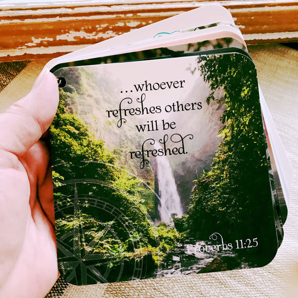 Scripture card of Proverbs 11:25 printed on a full color photo of plush greenery and waterfall as the backdrop. 