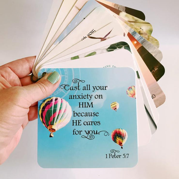 Scripture card on anxiety and worry with 1 Peter 5:7 printed over a photo of hot air balloons. Bible verse gift idea. Gifts with Bible verse on them.