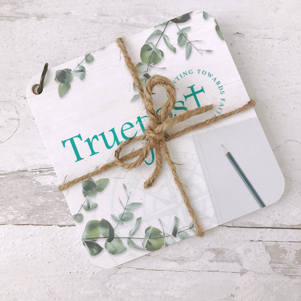 Truepost scripture devotional card set wrapped in jute twine laying on a rustic white table.