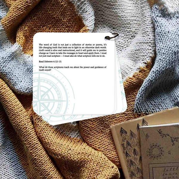 Devotion card on God's word being alive and instructional. Card is laying on a blue and brown blanket. Daily devotion.