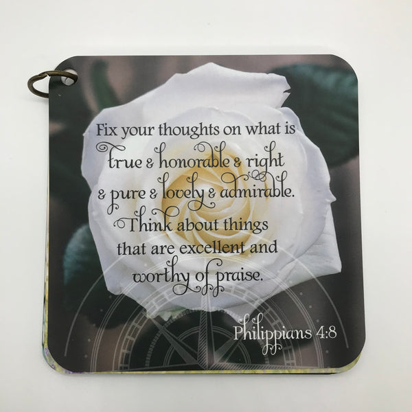 Scripture card of Philippians 4:8 fix your thoughts on what is true printed over a photo of a white rose. Daily Bible verse card.