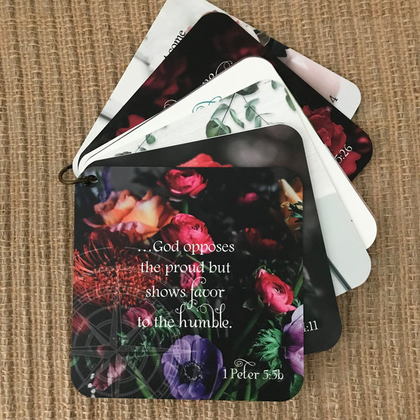 Scripture card of 1 Peter 5:5b God shows favor to the humble printed over a photo of multi colored flowers. Bible verse gift idea. Gifts with Bible verses on them.