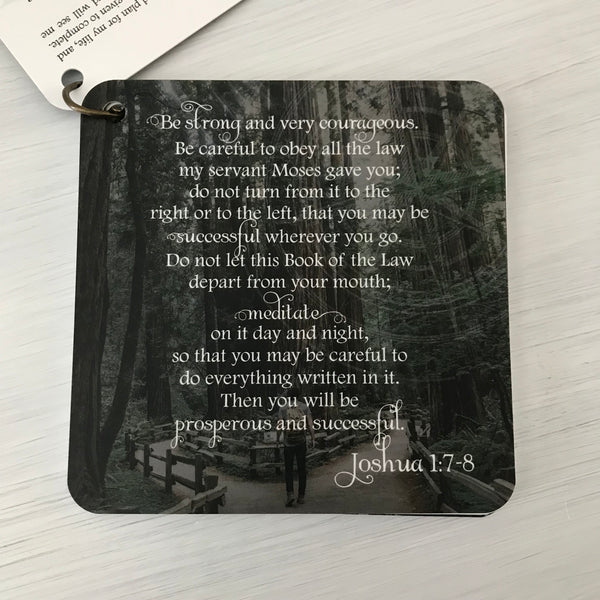 Scripture card of Joshua 1:7-8 is printed over a photo of a man with a backpack at the start of a walking path. The path has two possible directions. One path to the left and one to the right. The path is lined with a wooden fence and both paths go into the forest.