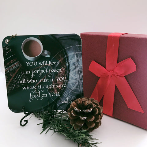 Scripture card of Isaiah 26:3 printed over a full color photo of coffee sitting on a round tray. The cards are displayed on a black iron easel beside a holiday gift box and greenery.