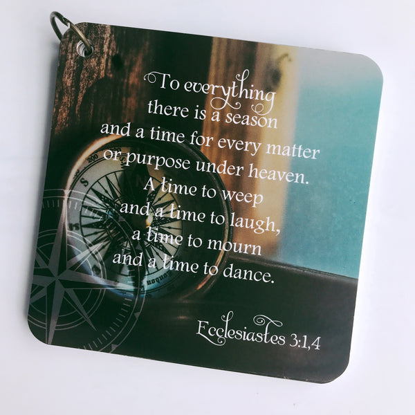 Scripture card on mourning and loss from Ecclesiastes 3:1,4 is printed over a photo of an old compass. The cards are laying over a white background.
