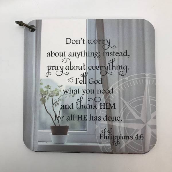 Scripture card for Philippians 4:6 printed on a photo of a window sill with a plant. Compass in the right bottom corner.