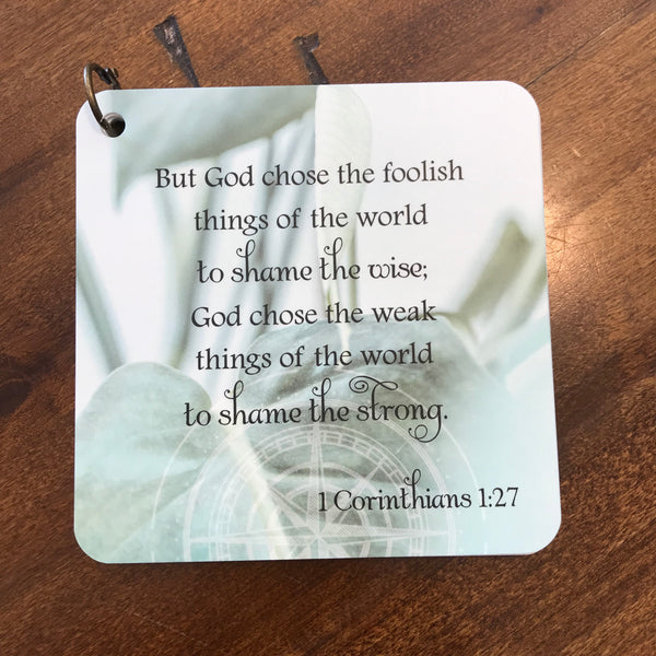 Scripture card of 1 Corinthians 1:27 printed over a photo of a green plant. 